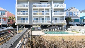 A multi-story building with balconies, a pool, and a wooden deck. - Oceanfront 3 BR Condo with a Shared Pool! Surfside By The Sea II 202 (Surfside Beach)