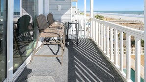 A balcony with a view of the beach, featuring two chairs and a small table. - Oceanfront 3 BR Condo with a Shared Pool! Surfside By The Sea II 202 (Surfside Beach)