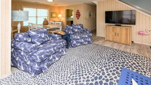Ein Wohnzimmer mit einer Couch, einem Fernseher und einem gemusterten Teppich.