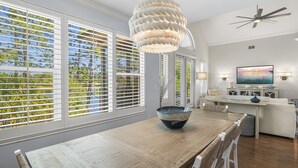 A dining area with a wooden table, a decorative bowl, and a ceiling fan.