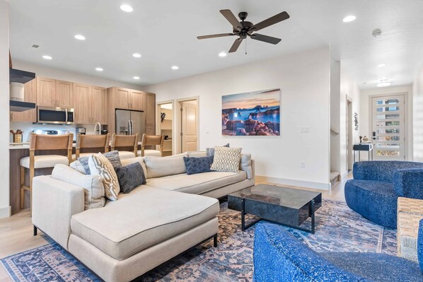Una sala de estar moderna con un sofá modular, una mesa de centro y un sillón azul.