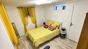 Een kleine, compacte slaapkamer met een bed, bureau en stoel.