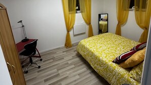 Een slaapkamer met een bed, een bureau en een stoel.