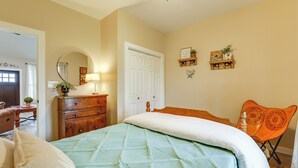 Un dormitorio con cama, cómoda, silla y una puerta.