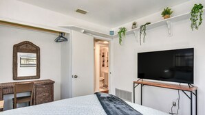 A bedroom with a bed, a desk, a chair, a television, and a wardrobe. - Fort Walton Home w/ Shared Pool - 2 Mi to Beach! (Fort Walton Beach)