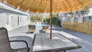 A patio with a table and chairs, a pool, and a wooden fence. - Fort Walton Home w/ Shared Pool - 2 Mi to Beach! (Fort Walton Beach)