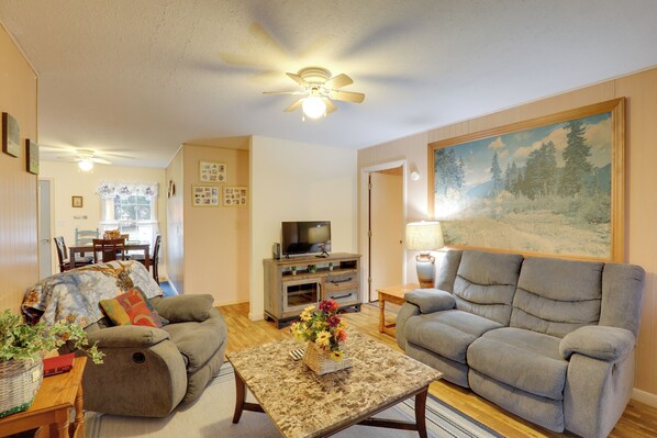 A living room with two sofas, a coffee table, a TV, and a painting on the wall. - Carolina Country Cabin! Hot Springs Getaway (Hot Springs)