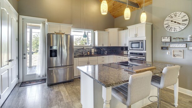 A modern kitchen with granite countertops, stainless steel appliances, and pendant lighting. - Walk to Beach: Stunning Gulfport Getaway (Gulfport)