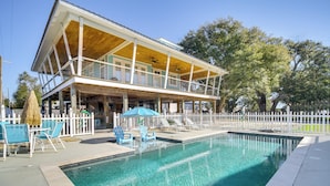 A two-story house with a swimming pool, outdoor seating, and a white picket fence. - Walk to Beach: Stunning Gulfport Getaway (Gulfport)