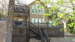 A two-story house with a balcony, a staircase, and a tree in the foreground. - Private Dock! Waterfront Sunrise Beach Rental (Sunrise Beach)