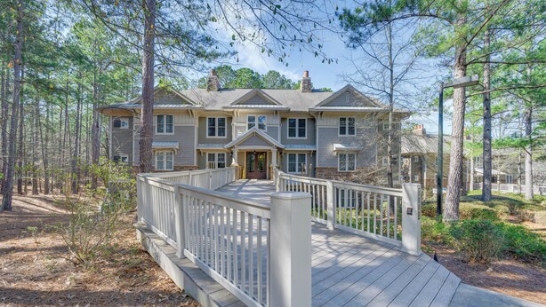 A large, two-story house with a covered porch and a white fence. - Chic Greensboro Condo w/ Lake Oconee Access! (Greensboro)