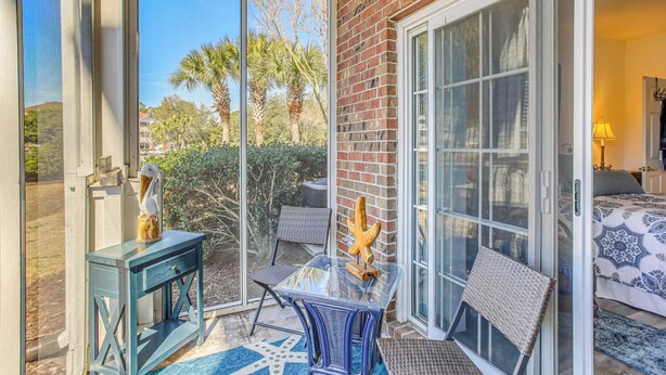 A patio with a glass door leading to a bedroom. - Swim, Golf & Unwind: Barefoot Resort Condo (North Myrtle Beach)