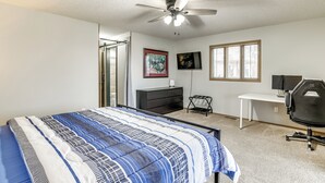 A bedroom with a bed, a desk, a chair, a ceiling fan, and a window. - Spacious Holiday Island Escape w/ Deck & Gas Grill (Eureka Springs)