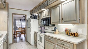 A kitchen with wooden cabinets, a refrigerator, an oven, and a microwave. - Spacious Holiday Island Escape w/ Deck & Gas Grill (Eureka Springs)