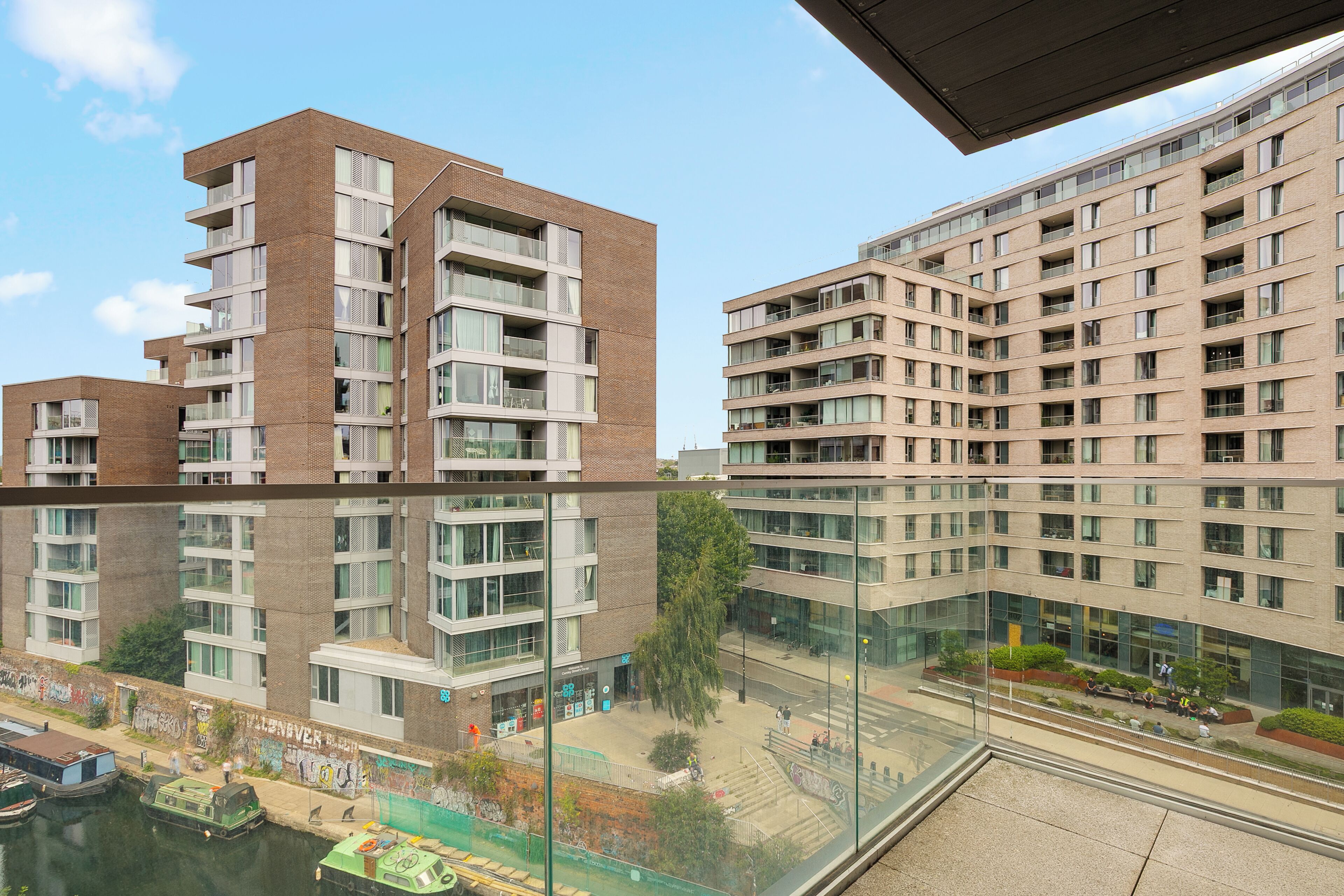 A high-rise residential building with multiple balconies and a glass facade.