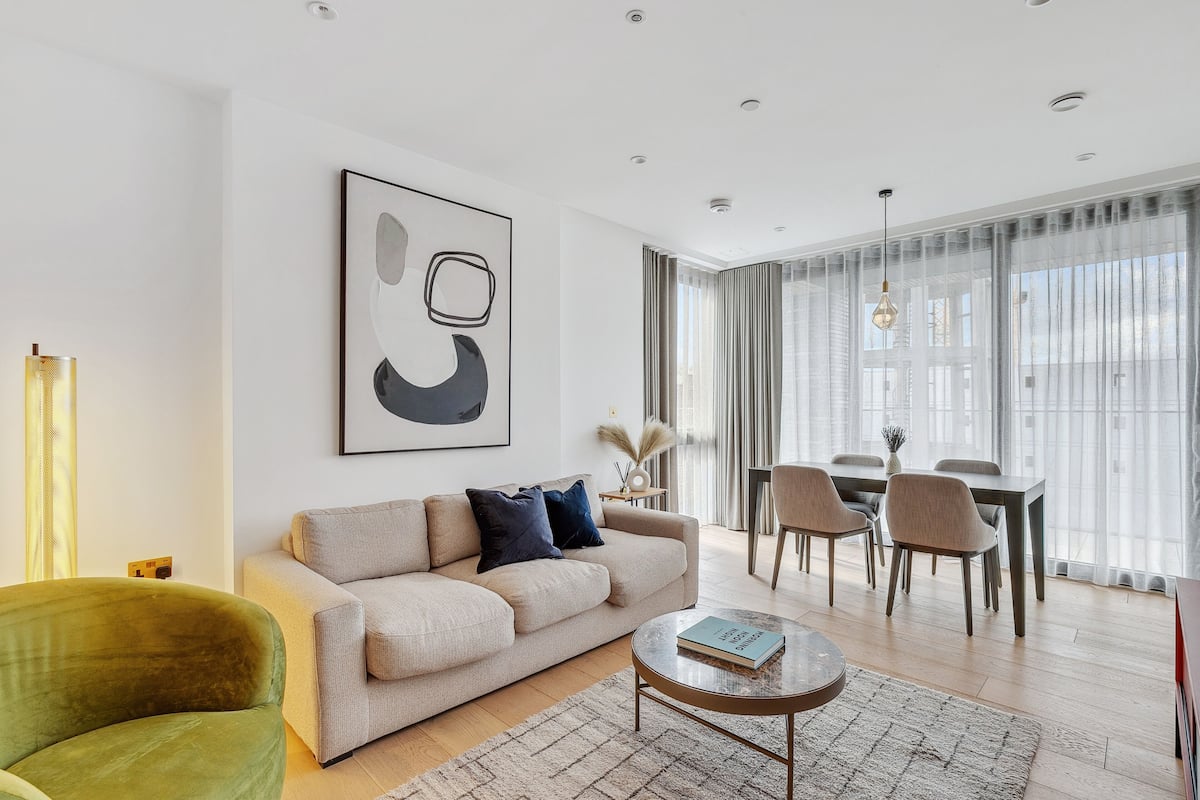 Una sala de estar moderna con un sofá, una mesa de centro y un comedor con sillas y una mesa.