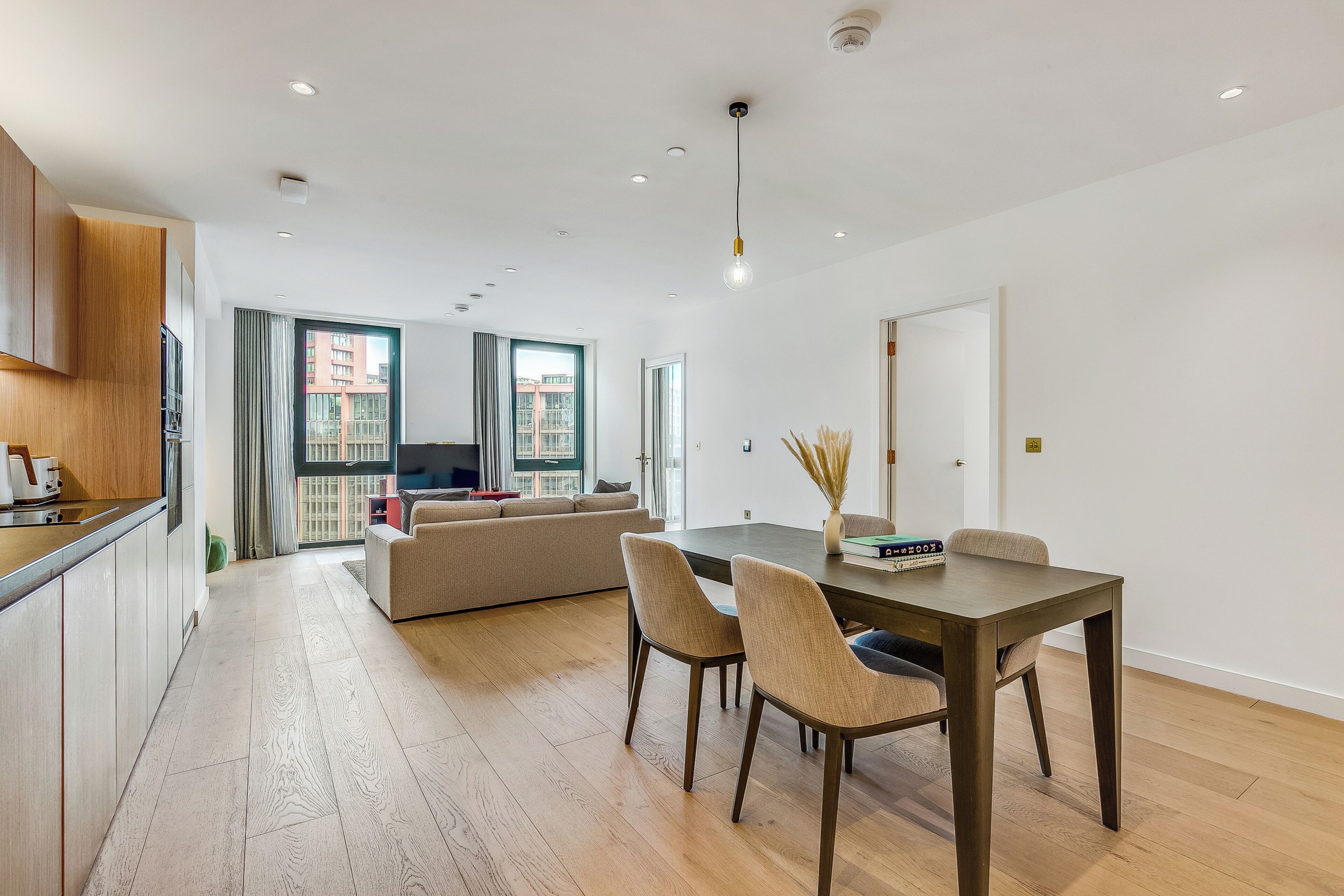 A modern apartment with a kitchen, dining area, and living room.