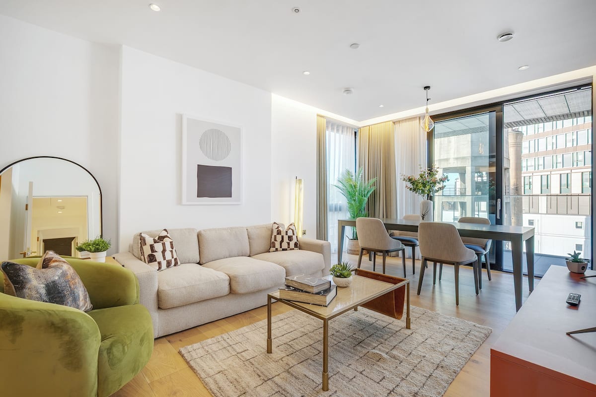 Una sala de estar moderna con sofá, mesa de centro y comedor.