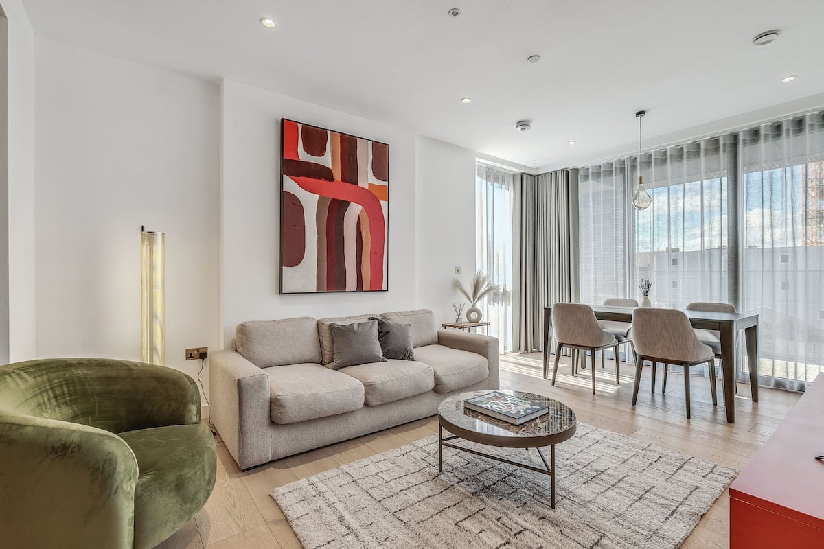 Una sala de estar moderna con sofá, mesa de centro y comedor.