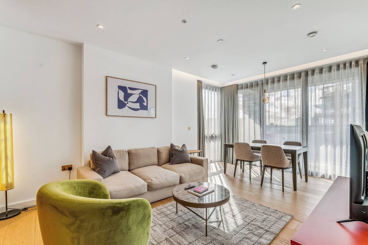 Una sala de estar moderna con un sofá, una mesa de centro y un comedor con sillas y una mesa.