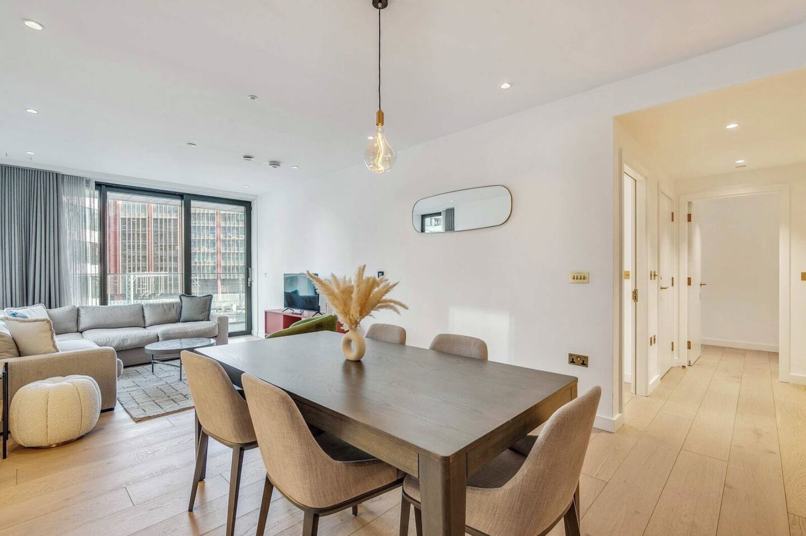 Una sala de estar moderna con comedor, ventanas amplias y diseño minimalista.
