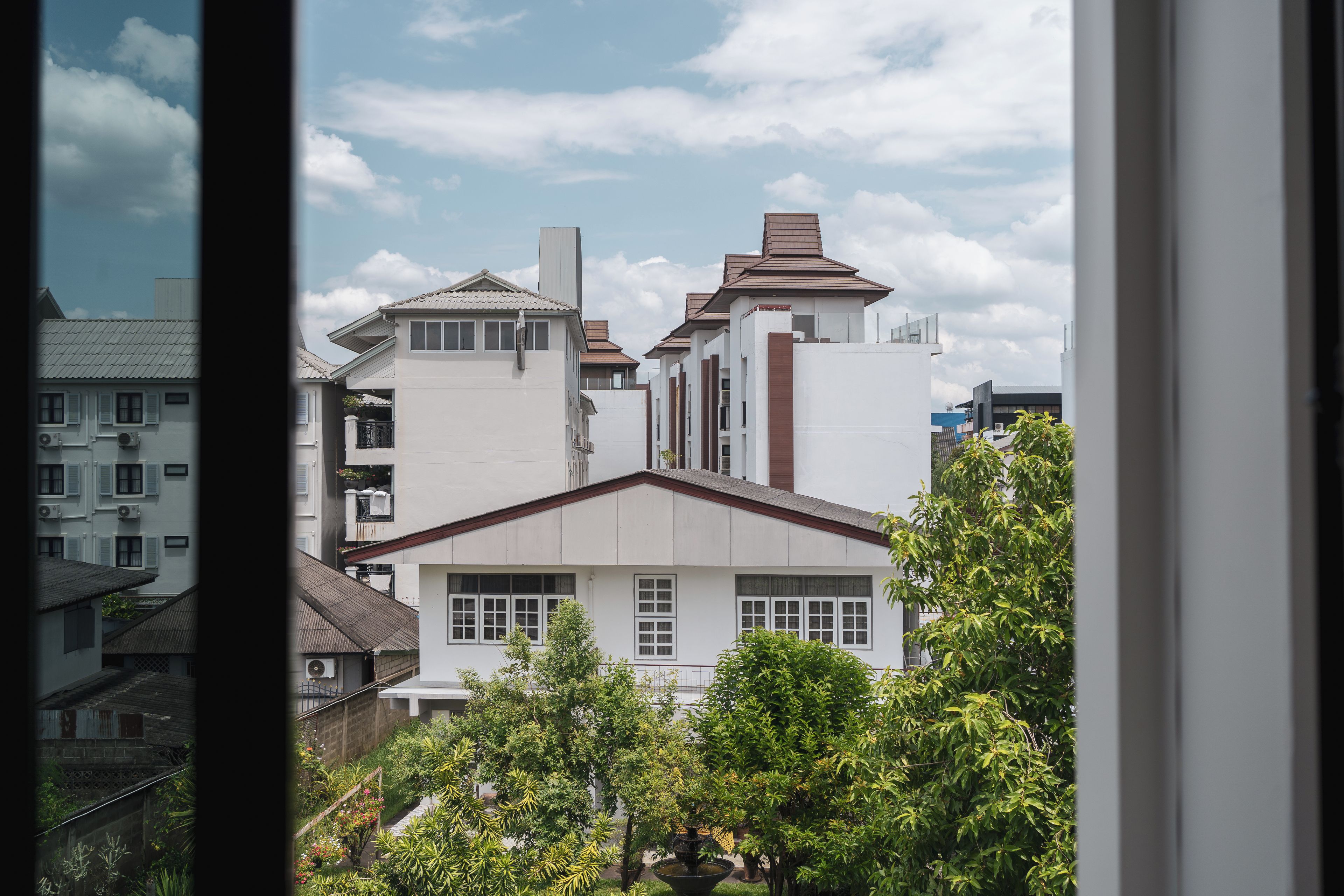 A residential building with a flat roof, multiple windows, and a visible chimney.
