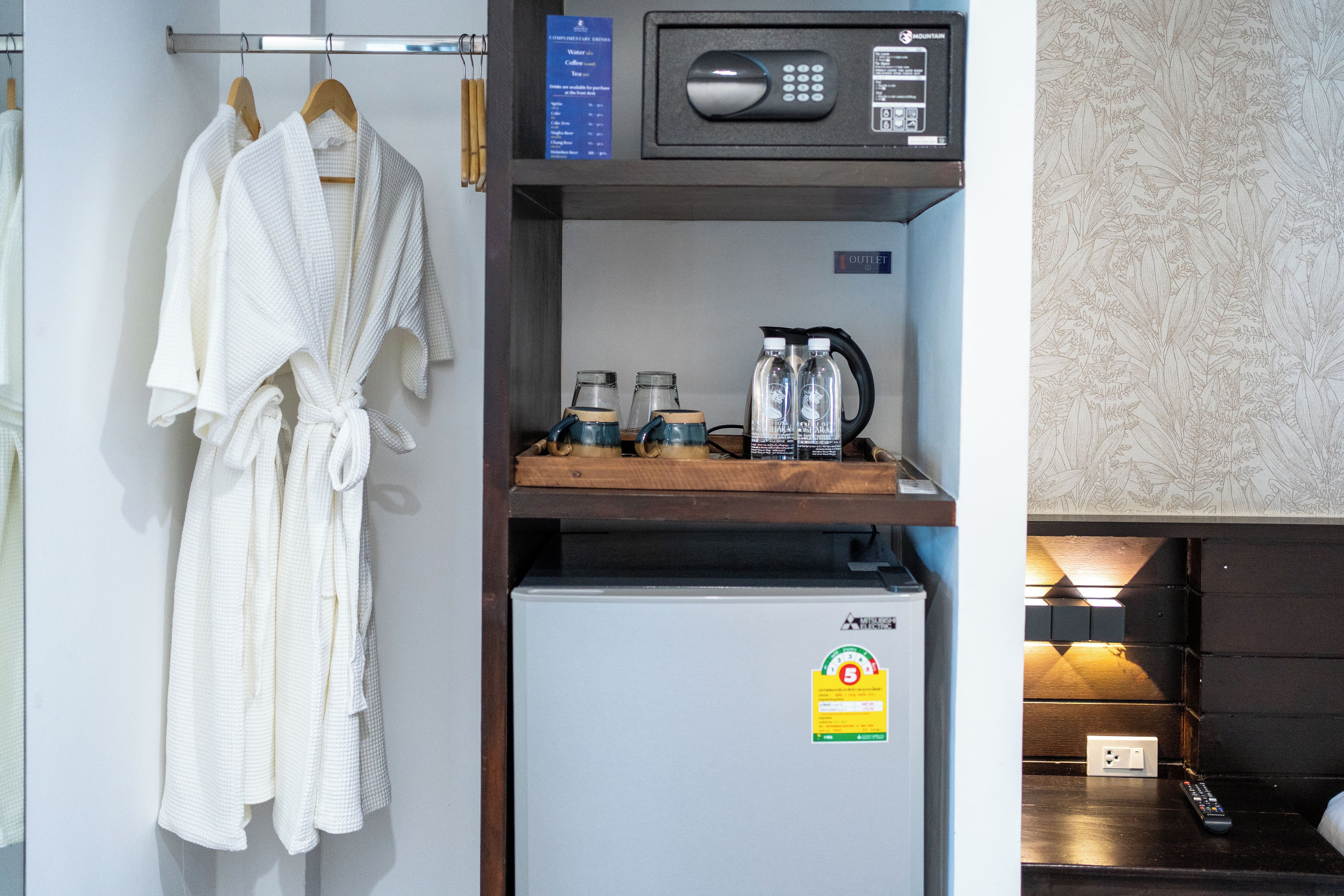 A hotel room with a minibar, a microwave, a refrigerator, and a coffee machine.