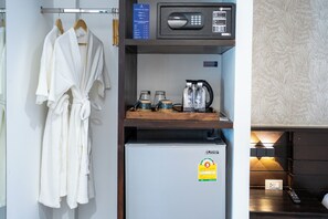 Une chambre d’hôtel équipée d’un mini-bar, d’un four à micro-ondes, d’un réfrigérateur et d’une machine à café.