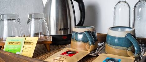A tray with tea bags, a kettle, and two mugs.