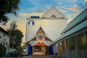 The exterior of Singharaj Boutique Hotel with a traditional architectural design, featuring a prominent entrance and a clear sky in the background. - Singharaj Boutique Hotel (Chiang Mai)