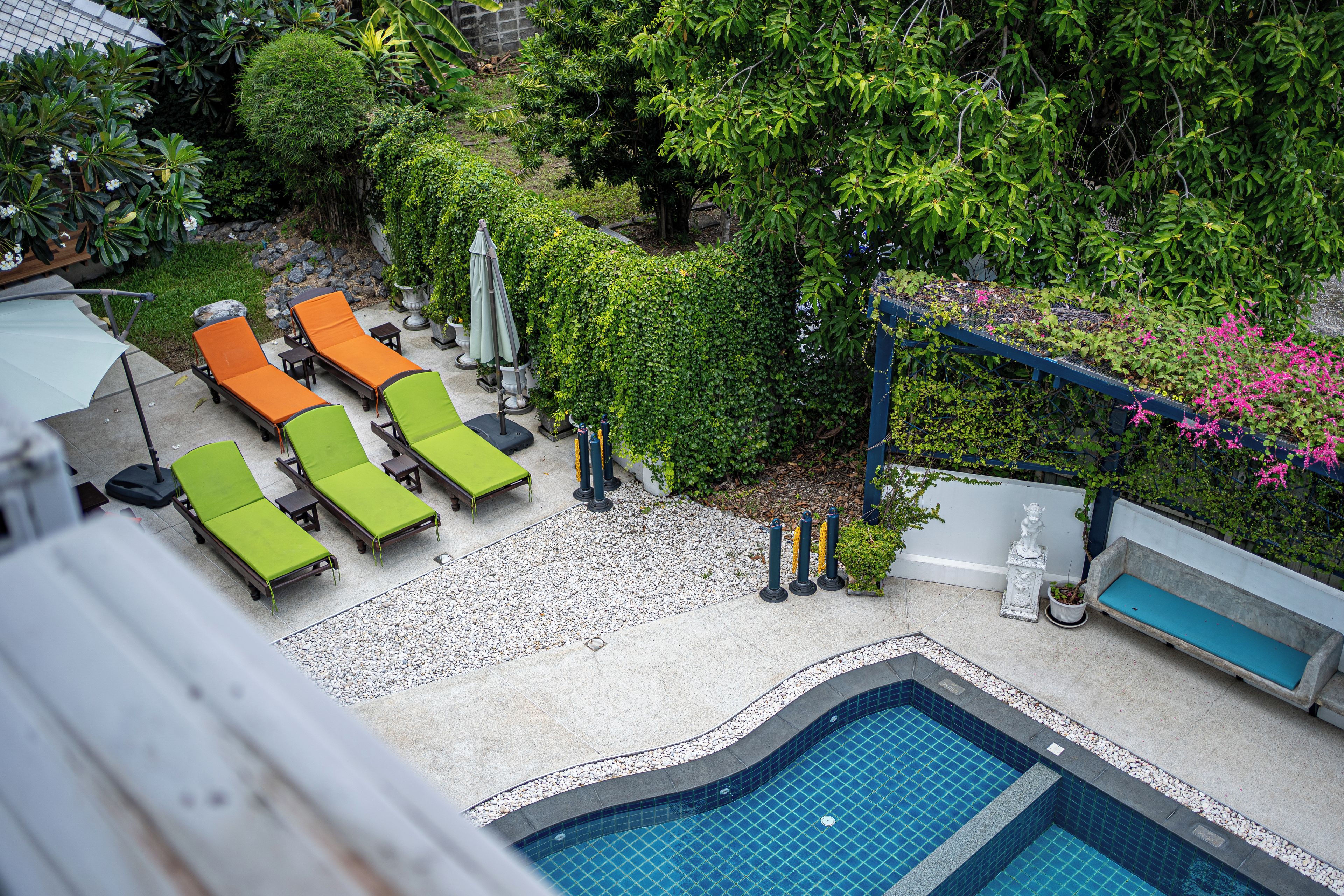 Un área de piscina en la azotea con sillones de descanso y una piscina pequeña.
