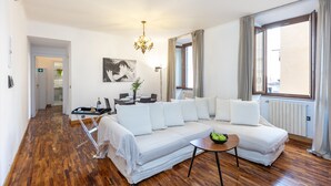 En moderne stue med en sofa, et lille bord og en lysekrone.