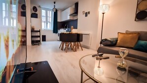 Ein modernes Wohnzimmer mit einem Glastisch, einer Couch und einem Essbereich mit Tisch und Stühlen.
