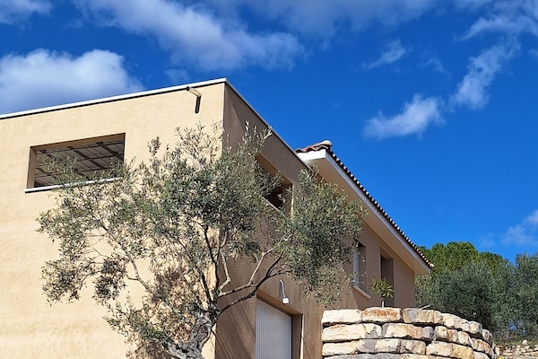 porte d'entrée sur la droite. Terrasse couverte sur la gauche.