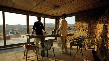 Una habitación con ventanas amplias, pared de piedra y techo de madera.