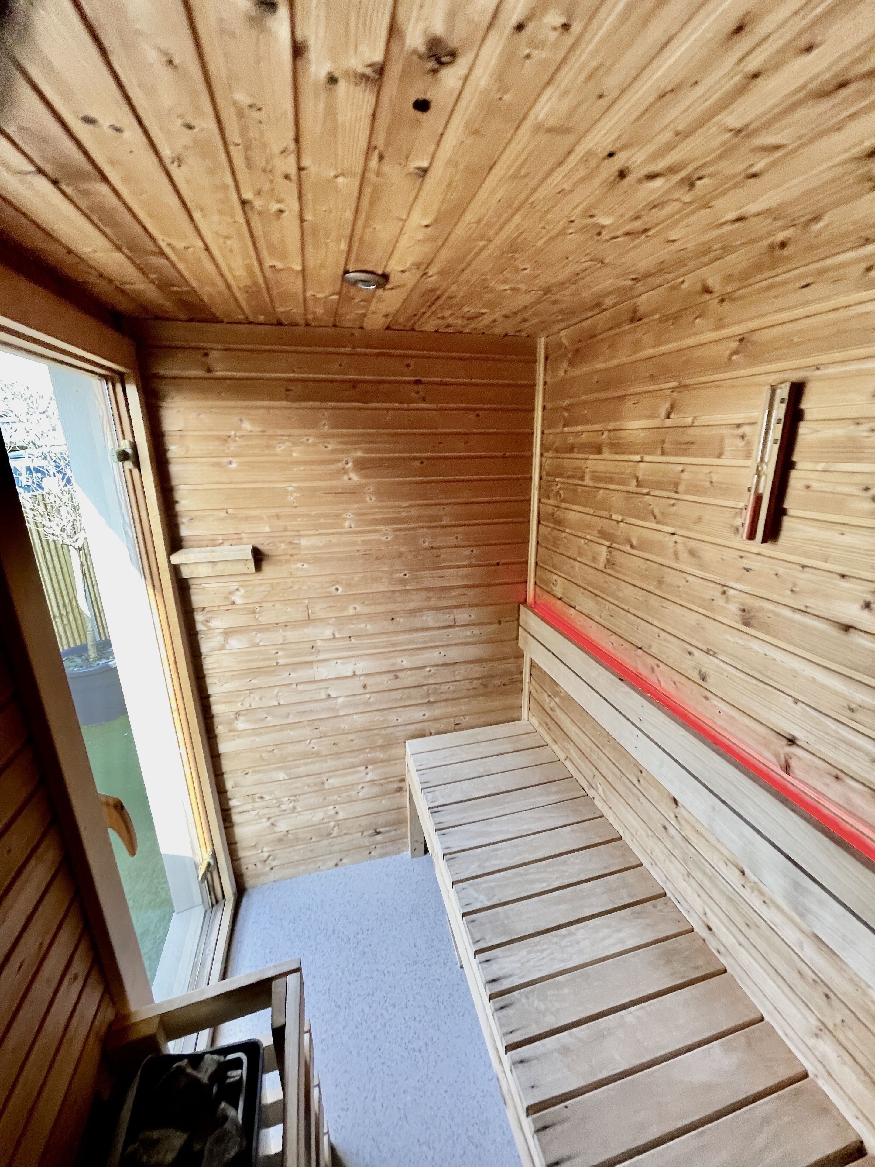 Un interior de madera con un banco y una ventana.