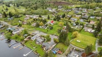 Luchtbeeld van een woongebied met huizen, een steiger en een groot, rode gebouw.