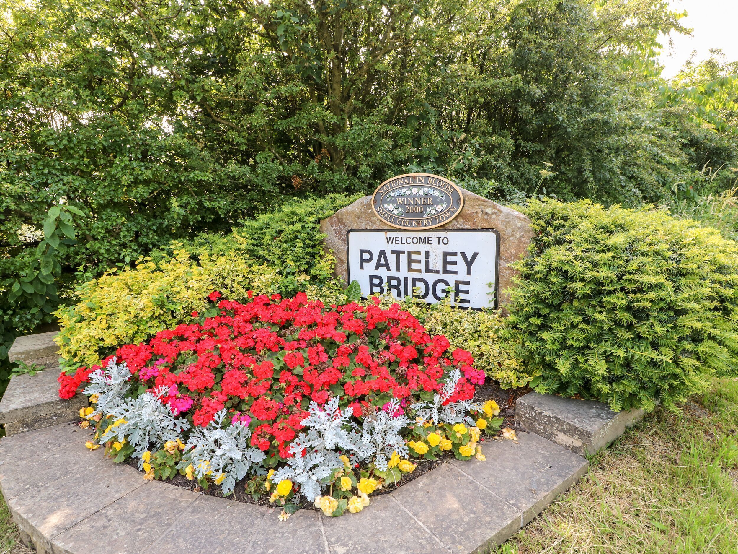 A welcome sign to Pateley Bridge with a plaque indicating it was a National in Bloom Winner in 2000.