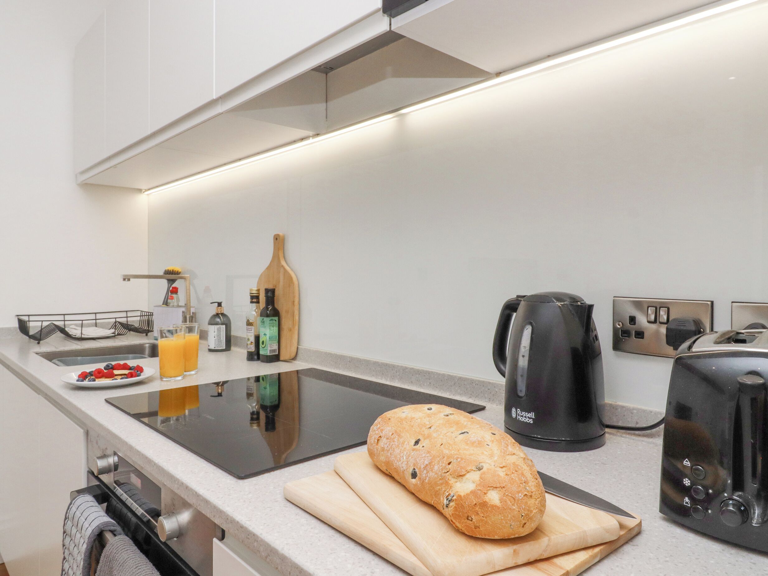 Een moderne keuken met een aanrecht, een brood, een waterkoker en een broodrooster.