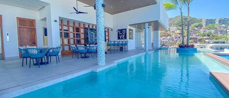 Un área de piscina moderna con vistas despejadas a las colinas circundantes.