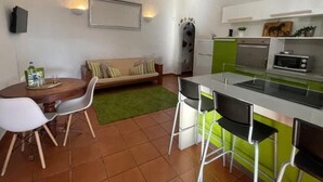 A compact kitchen with a dining area, a sofa, and a small table. - Bed&ride, Modern Country Apartment Telde (Ojos de Garza)