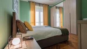 A bedroom with a bed, a bedside table with a lamp, and a wardrobe. - Modern Apartment in Santa Rita by Wonderful Italy (Torino)