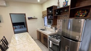 Una cocina moderna con encimera de mármol, electrodomésticos de acero inoxidable y horno empotrado.