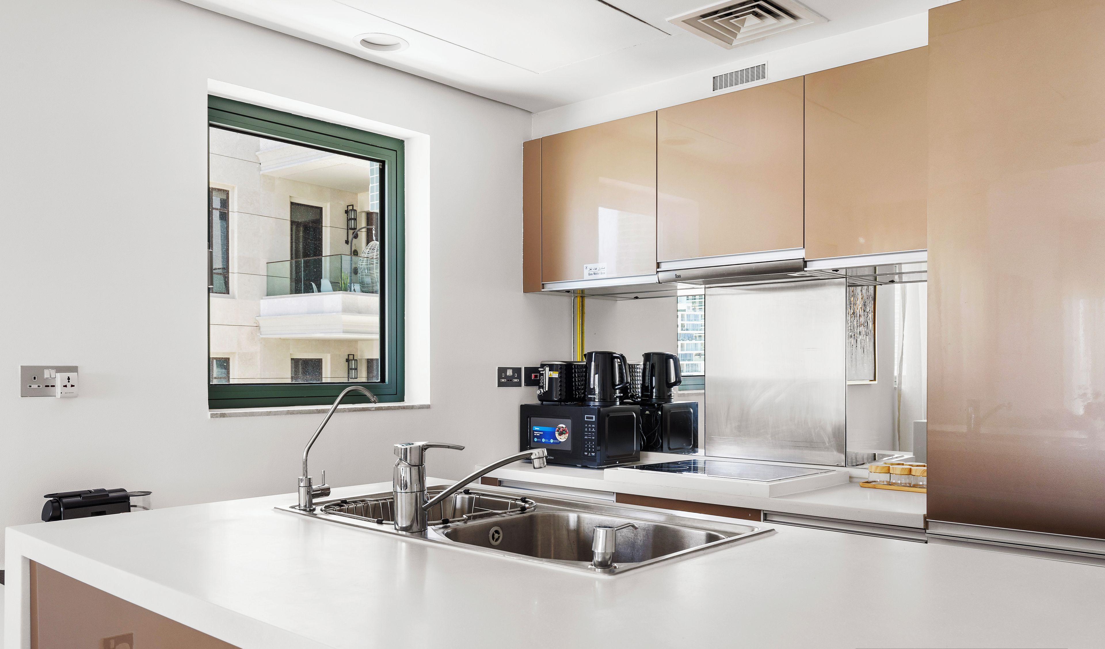 Cozinha moderna com uma ilha grande, eletrodomésticos de aço inoxidável e vista para a varanda.