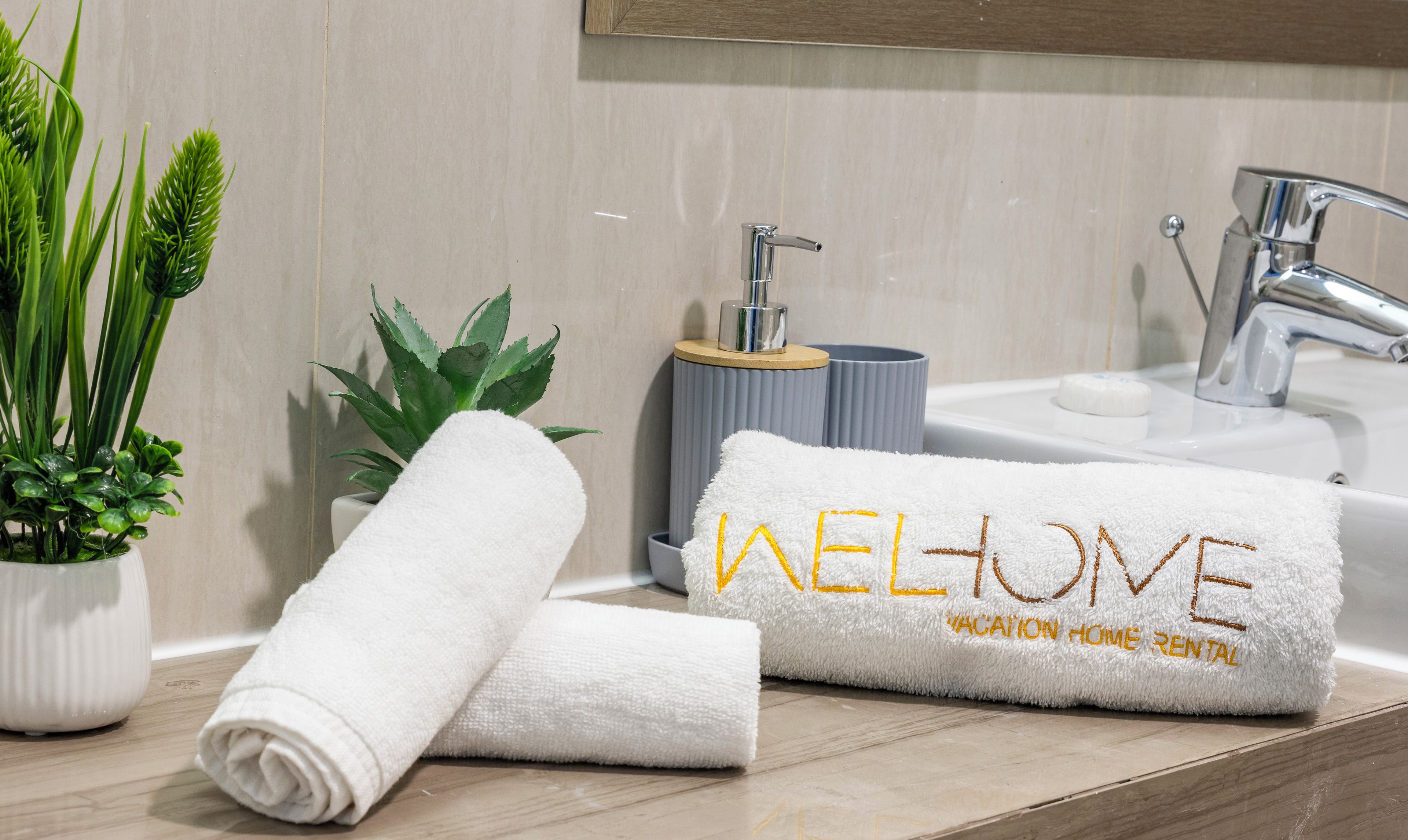 A bathroom with a sink, a towel, and a potted plant.