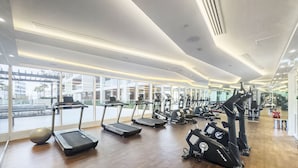 A modern gym with treadmills, elliptical machines, and a rowing machine. - WelHome - Cozy Studio Apt. with Private Balcony in Arjan (Dubai)