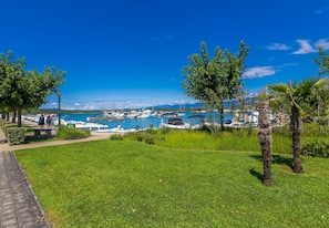 A marina with boats docked, surrounded by greenery and trees. - Apartment DEA with heated pool and sea view (Klimno)