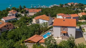 Un quartier résidentiel situé sur la côte, avec des maisons, une piscine et une vue sur la mer.