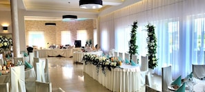 A banquet hall with round tables, white tablecloths, and floral centerpieces. - Hotel Graal (gmina Klaj)