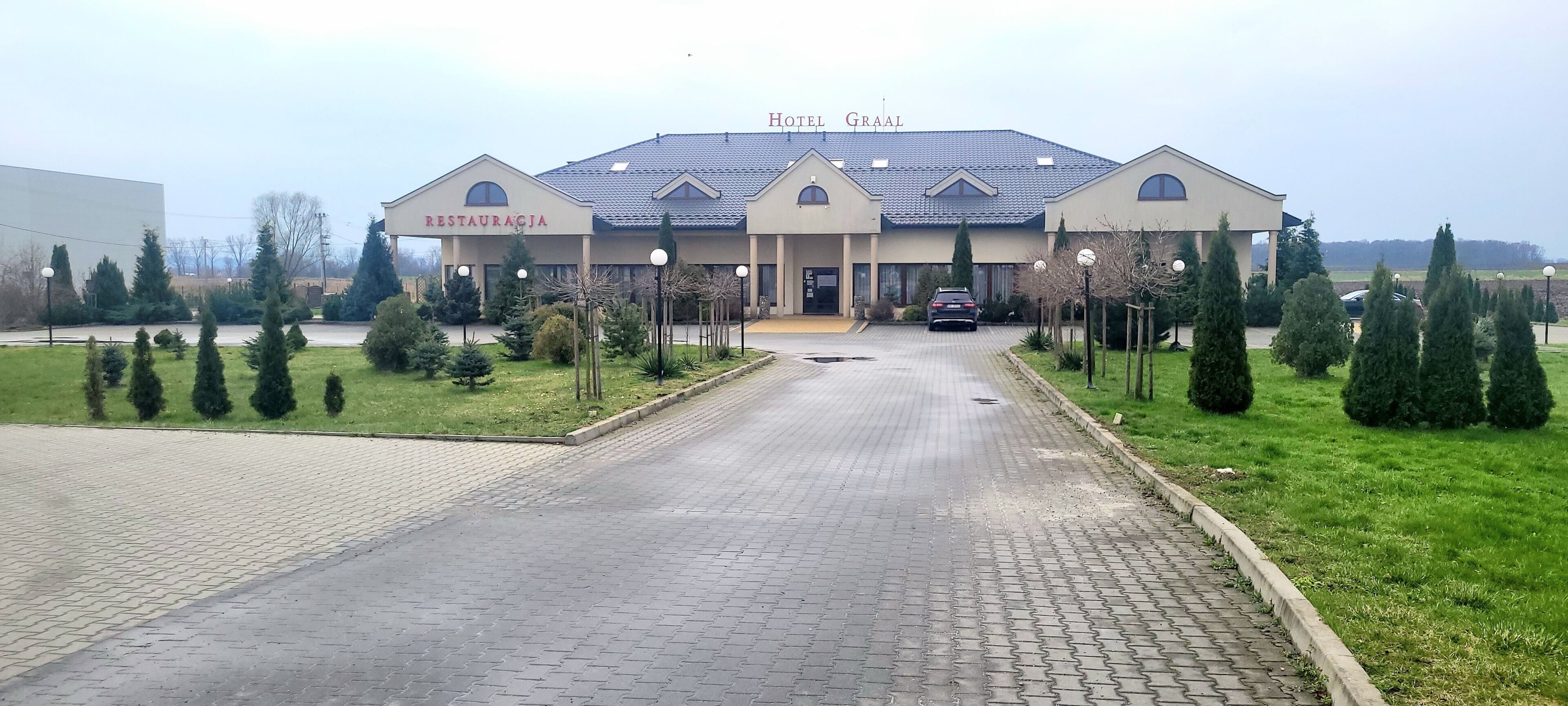A hotel with a restaurant, paved entrance, and well-maintained landscaping.